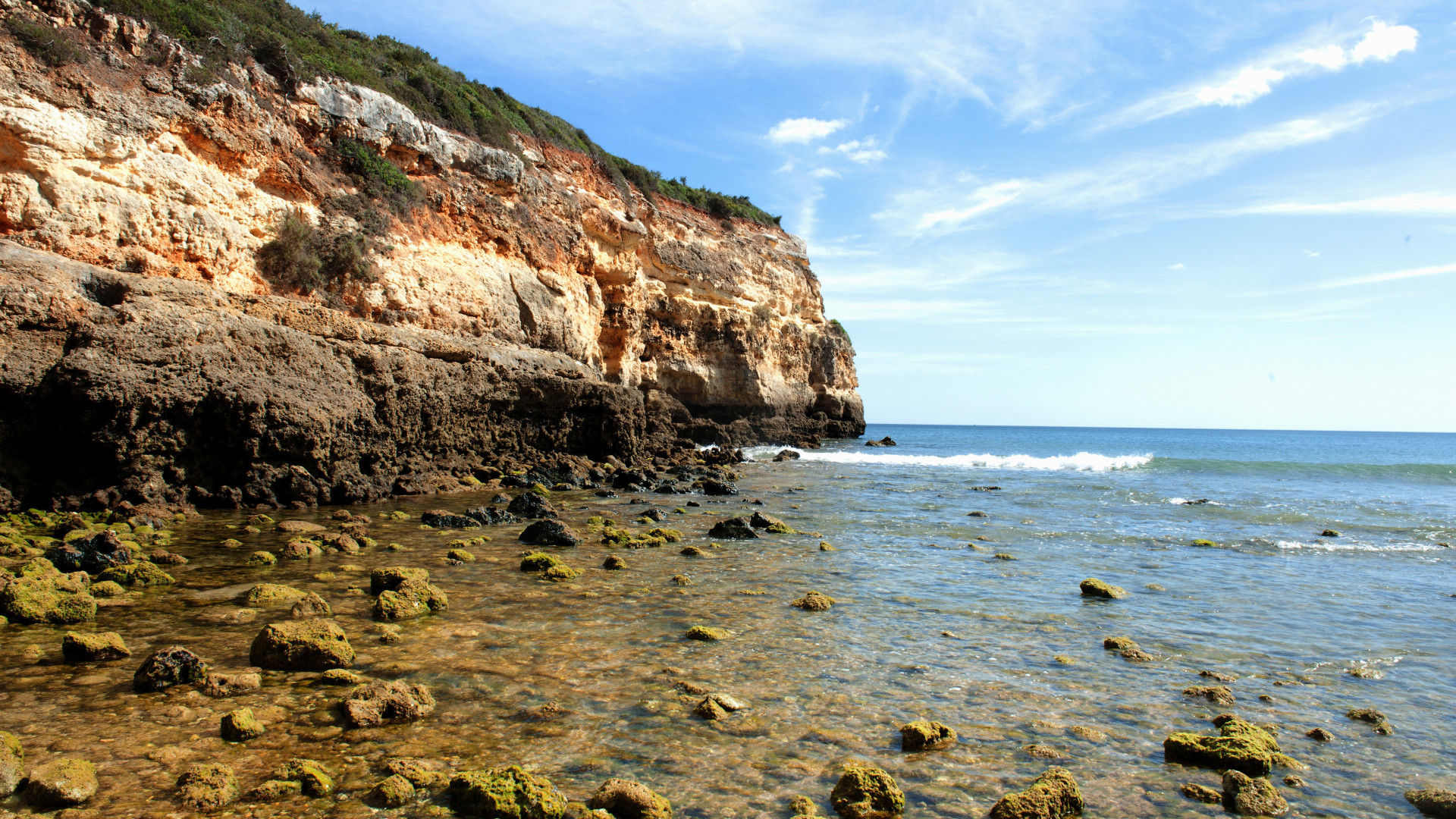 Olas sobre una pequeña roca cubierta de musgo